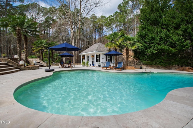 outdoor pool with a patio and an outdoor structure