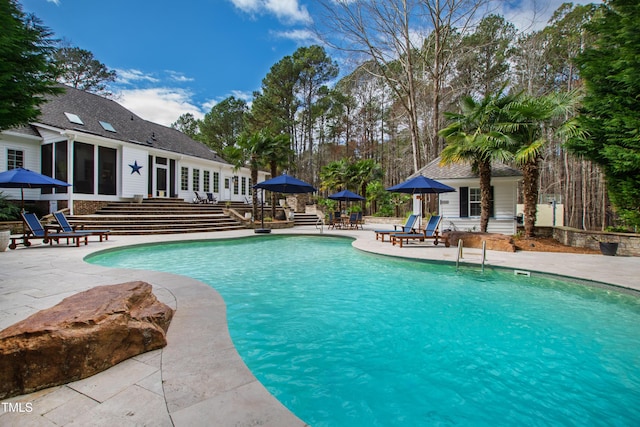 outdoor pool featuring a patio area and a sunroom