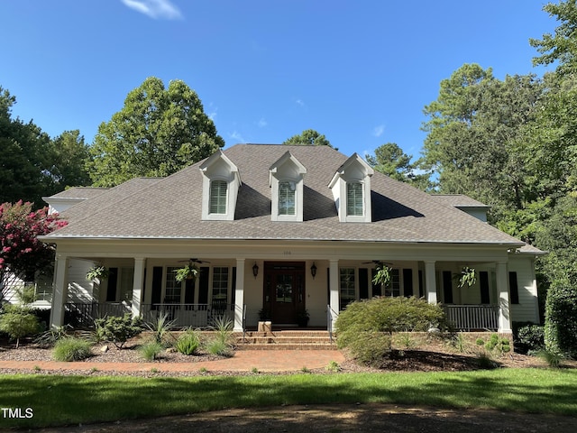 new england style home featuring a porch, a ceiling fan, and a shingled roof