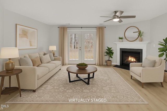 5625 Fieldcross Ct, Raleigh, NC 27610 - living room with wood finished floors, a fireplace with flush hearth, a ceiling fan, and french doors