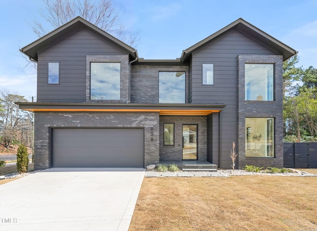 contemporary home featuring a front yard, fence, concrete driveway, and brick siding