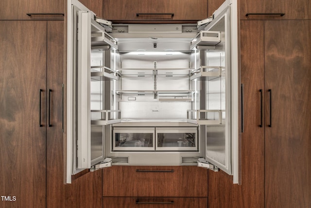 kitchen featuring modern cabinets, brown cabinets, and refrigerator