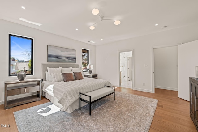 bedroom with baseboards, recessed lighting, and light wood-style floors