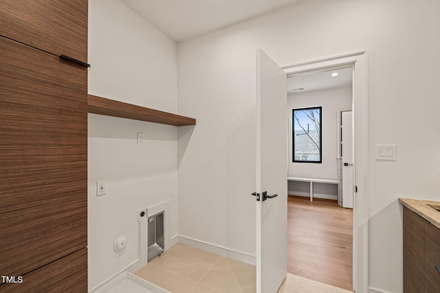 washroom with laundry area, light wood finished floors, and hookup for an electric dryer