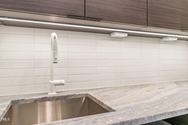 room details with light stone counters and a sink