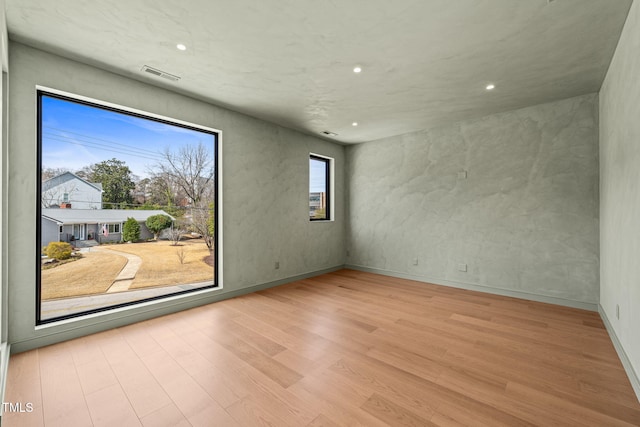 unfurnished room with recessed lighting, visible vents, baseboards, and wood finished floors