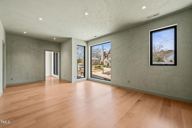 spare room featuring baseboards, wood finished floors, visible vents, and recessed lighting