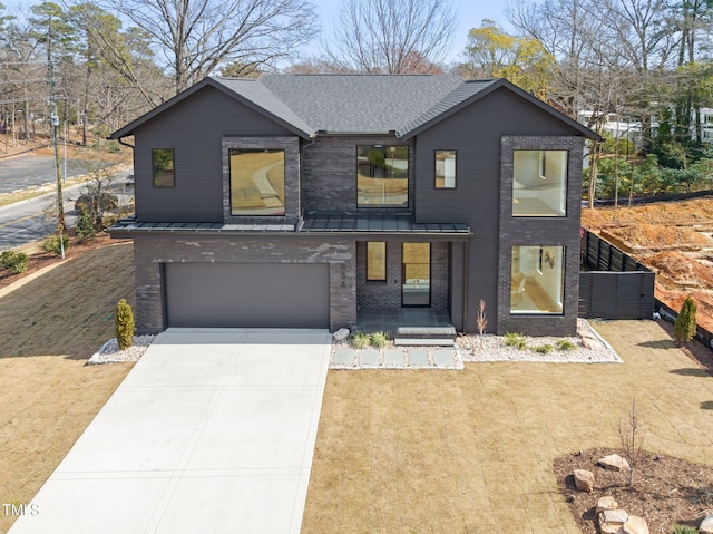 view of front of home with brick siding, an attached garage, a standing seam roof, metal roof, and driveway