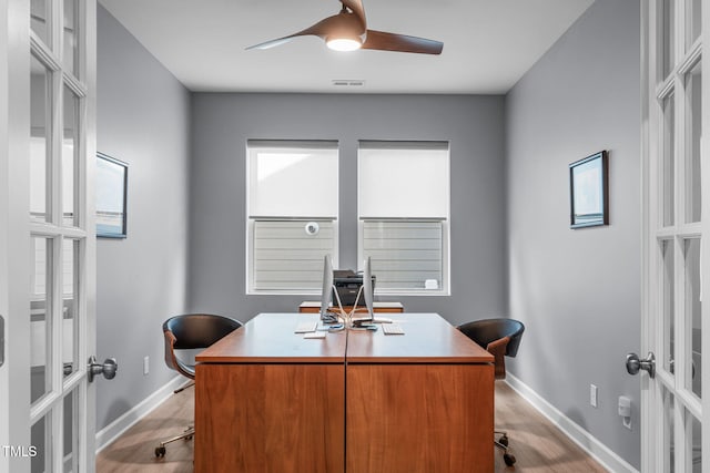 office featuring french doors, visible vents, light wood-style floors, ceiling fan, and baseboards