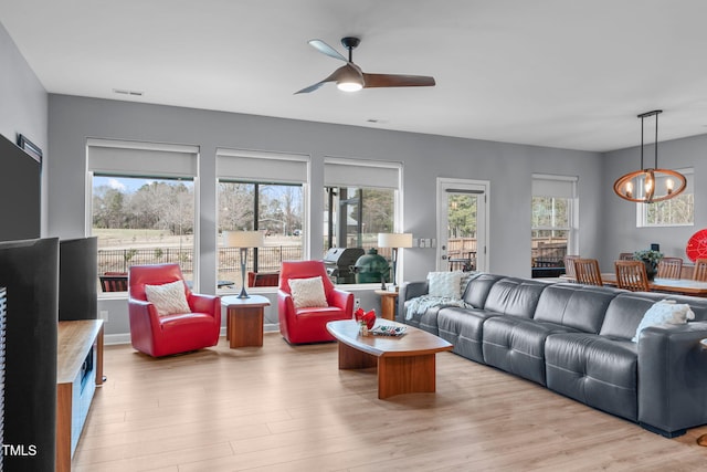 living area with visible vents, light wood-type flooring, and a wealth of natural light