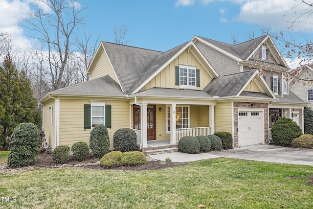 view of front facade featuring a porch, board and batten siding, a front yard, a garage, and driveway