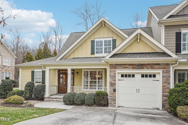 view of front of home featuring stone siding, a porch, board and batten siding, and concrete driveway