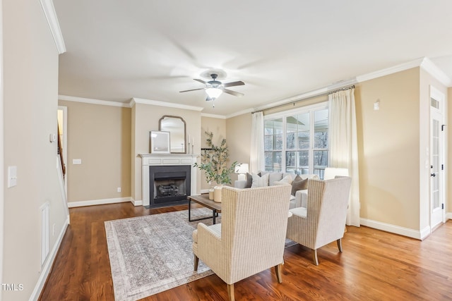 living area featuring ornamental molding, baseboards, a fireplace with flush hearth, and wood finished floors