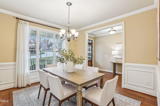 dining room with ornamental molding, dark wood-style flooring, a wainscoted wall, and a decorative wall