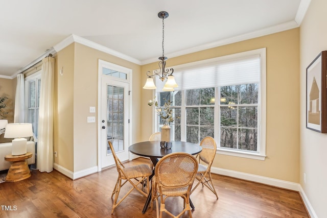 dining space with baseboards, crown molding, and wood finished floors