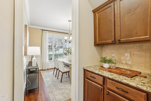 kitchen featuring tasteful backsplash, dark wood-type flooring, light stone countertops, and brown cabinets