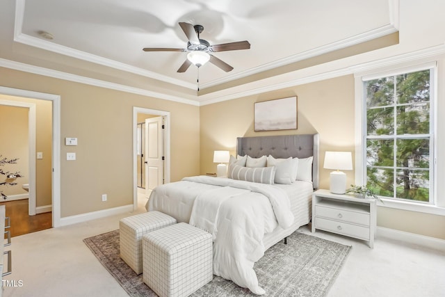 bedroom with ceiling fan, carpet flooring, baseboards, ensuite bath, and crown molding