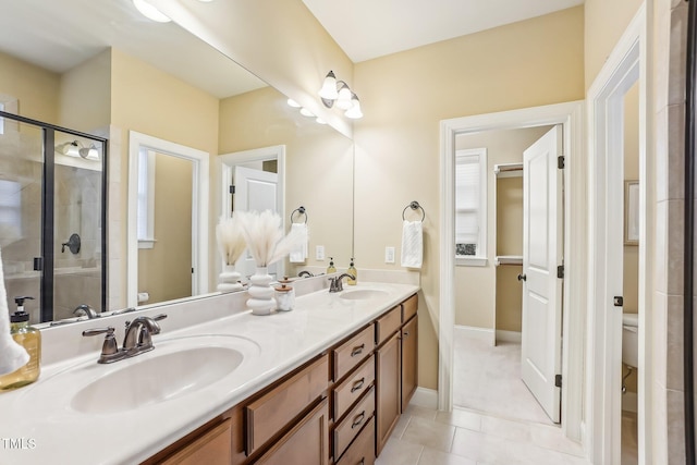 full bathroom featuring a stall shower, a sink, toilet, and double vanity