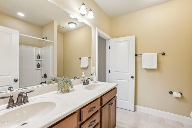 full bathroom featuring a sink, baseboards, and double vanity