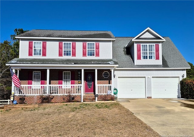 traditional-style home with a shingled roof, covered porch, a front yard, a garage, and driveway