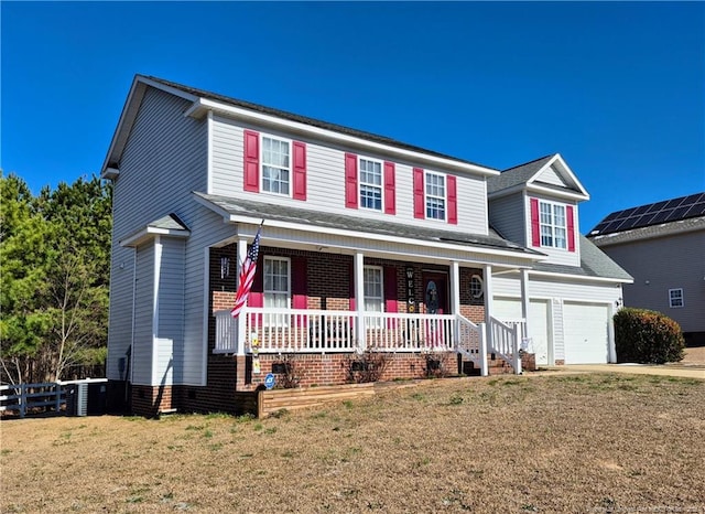 traditional-style house with concrete driveway, an attached garage, covered porch, fence, and a front yard