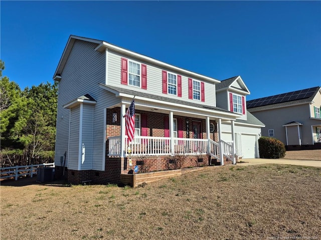 traditional home with a porch, central AC unit, a garage, driveway, and a front lawn