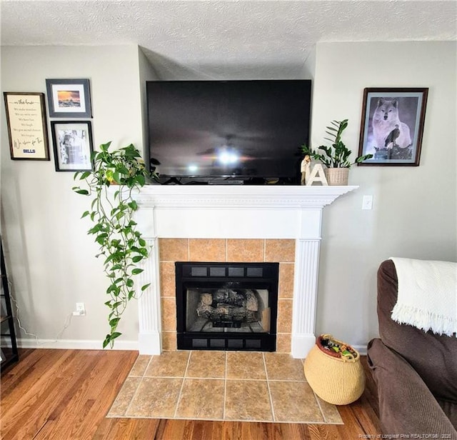 11 Scotland Dr, Spring Lake, NC 28390 - living area with baseboards, a tile fireplace, wood finished floors, and a textured ceiling