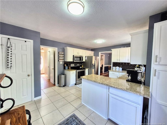 11 Scotland Dr, Spring Lake, NC 28390 - kitchen with a peninsula, appliances with stainless steel finishes, backsplash, and white cabinetry
