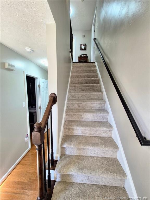 11 Scotland Dr, Spring Lake, NC 28390 - stairs with baseboards, wood finished floors, and a textured ceiling