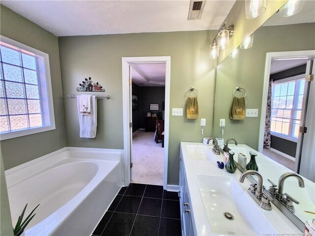 11 Scotland Dr, Spring Lake, NC 28390 - bathroom featuring visible vents, a bath, a sink, double vanity, and tile patterned floors