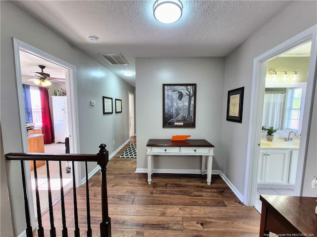 11 Scotland Dr, Spring Lake, NC 28390 - hall featuring a textured ceiling, dark wood finished floors, visible vents, and a wealth of natural light