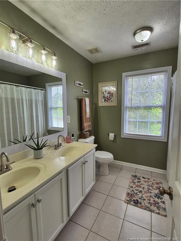 11 Scotland Dr, Spring Lake, NC 28390 - full bath with a sink, tile patterned flooring, visible vents, and a wealth of natural light