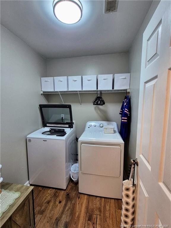 11 Scotland Dr, Spring Lake, NC 28390 - laundry area featuring dark wood-type flooring, visible vents, washing machine and dryer, and laundry area