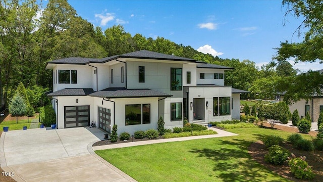 contemporary house featuring stucco siding, driveway, a front yard, and a garage