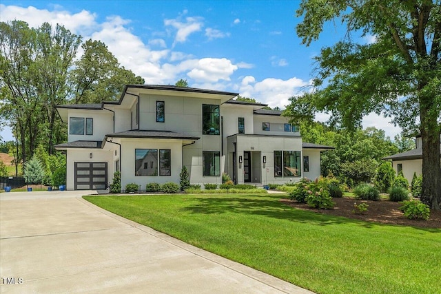 view of front facade featuring stucco siding, concrete driveway, a garage, and a front yard