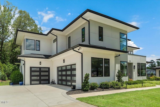 modern home featuring concrete driveway, a garage, and stucco siding