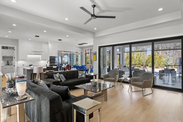 living room featuring recessed lighting, light wood-type flooring, and a ceiling fan