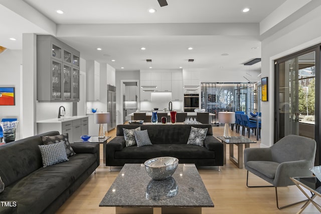 living area with a ceiling fan, recessed lighting, and light wood-style floors