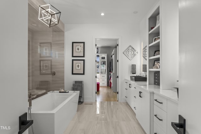 full bathroom with a soaking tub, recessed lighting, vanity, and built in features