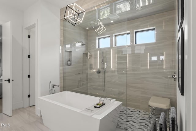 bathroom featuring a tile shower and a freestanding tub