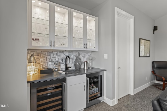 bar featuring wine cooler, dark carpet, indoor wet bar, and a sink