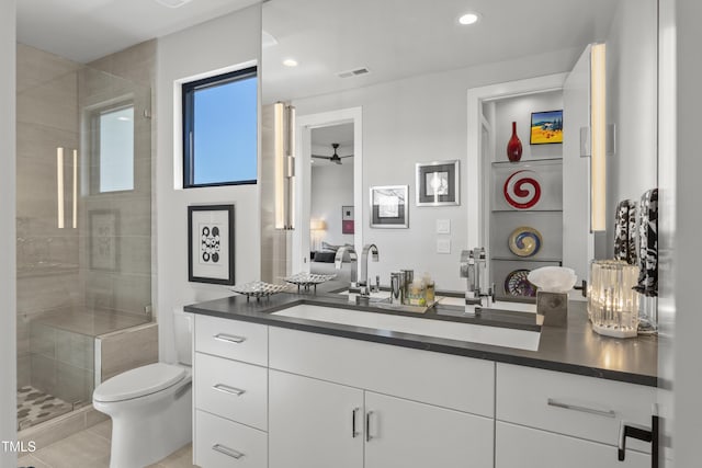 bathroom featuring vanity, a ceiling fan, visible vents, a shower stall, and toilet