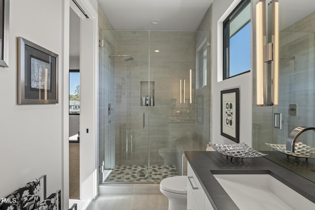 full bathroom with a wealth of natural light, a shower stall, toilet, and vanity