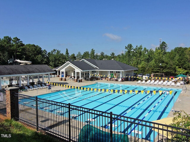 pool with a patio area and fence