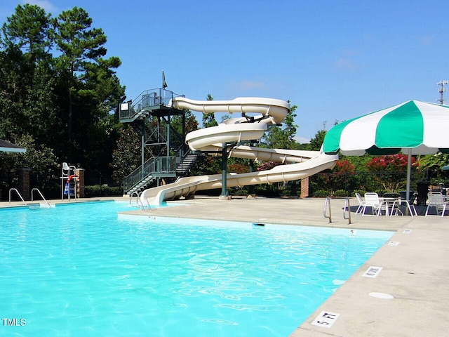 pool with stairs and a water slide