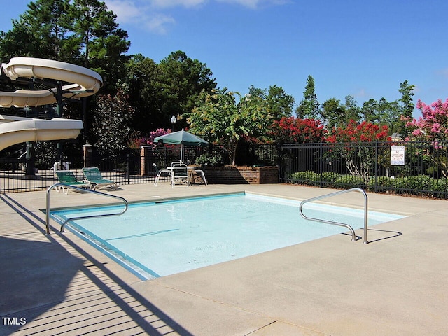 community pool with fence and a patio