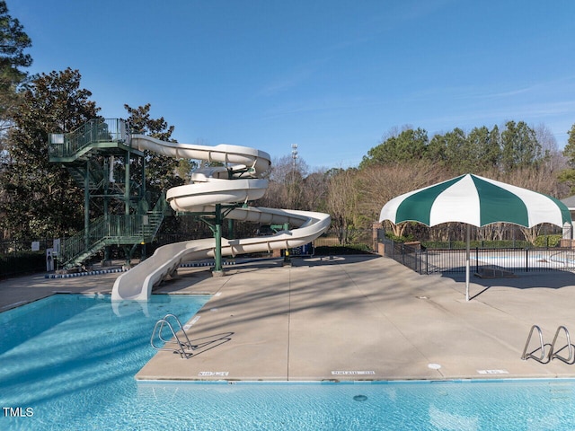 pool featuring a water slide and fence