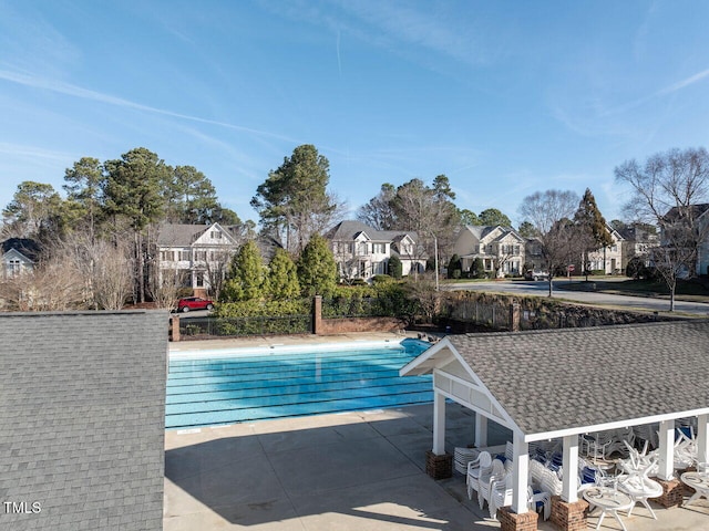 outdoor pool with a patio area and a residential view