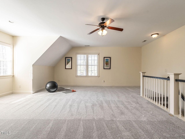 additional living space with baseboards, ceiling fan, vaulted ceiling, and light colored carpet