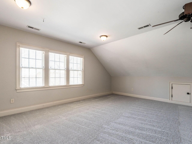 additional living space featuring visible vents, vaulted ceiling, and carpet flooring